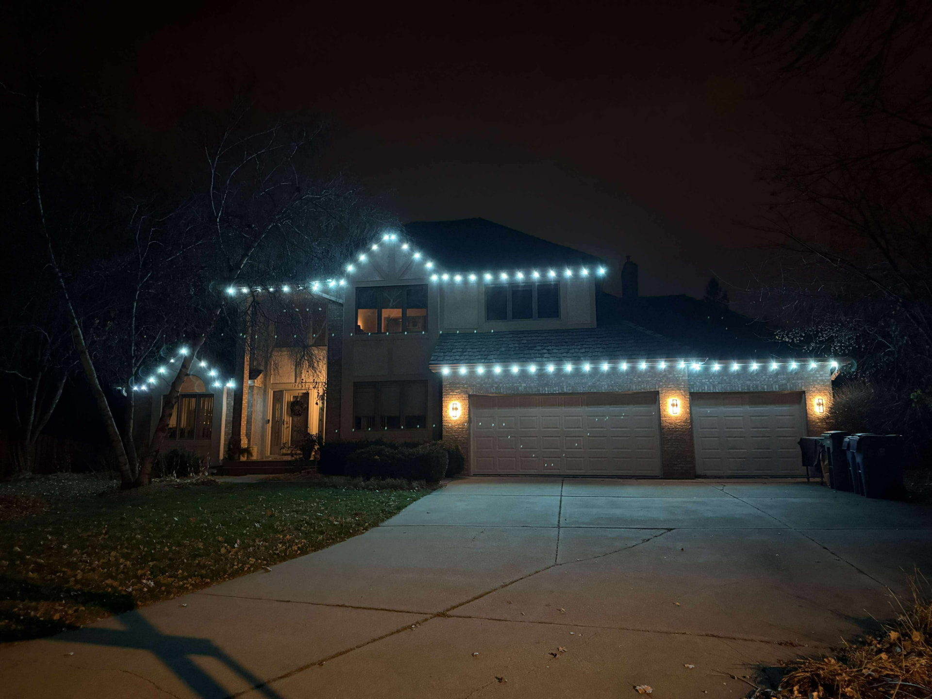 Warm white string-style permanent lighting across a large roofline